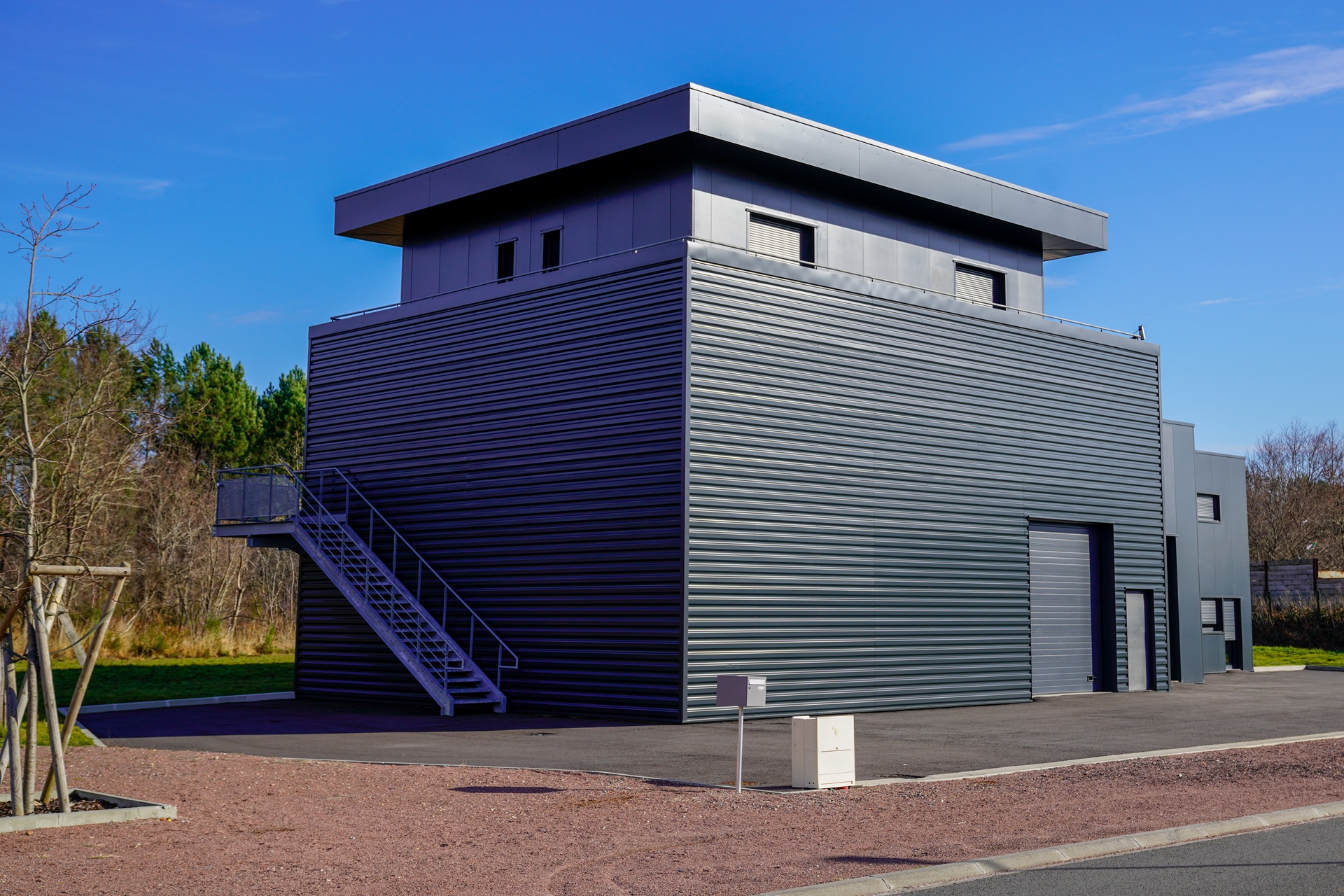 Dunkelgraues, modernes Industriegebäude mit Außentreppe | Mülltonnenbox 2er